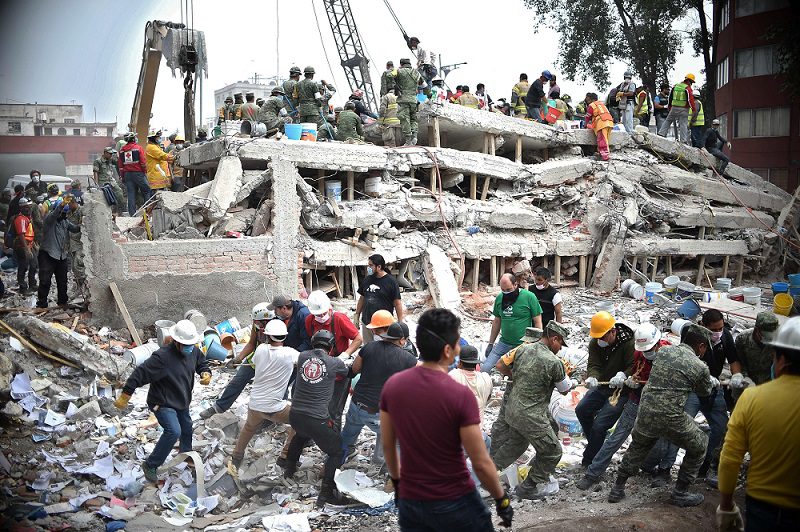 Rescuers, firefighters, policemen, soldiers and volunteers search for survivors in a flattened building in Mexico City on September 20, 2017 a day after a strong quake hit central Mexico.A powerful 7.1 earthquake shook Mexico City on Tuesday, causing panic among the megalopolis' 20 million inhabitants on the 32nd anniversary of a devastating 1985 quake. / AFP PHOTO / Yuri CORTEZ