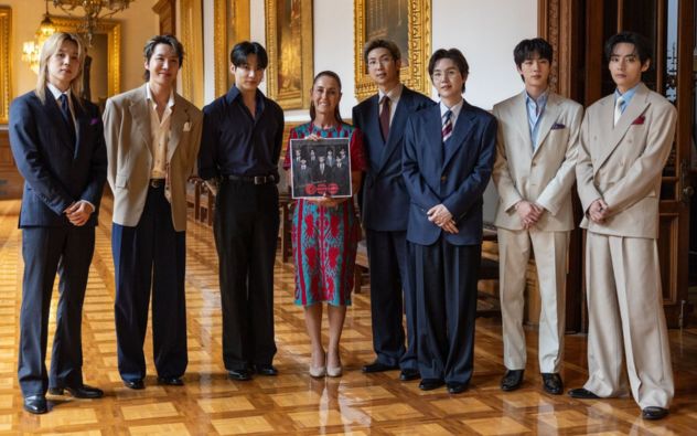 Integrantes de BTS saludando desde el balcón de Palacio Nacional junto a la presidenta de México ante miles de fans en el Zócalo.