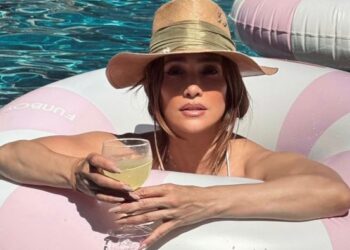 Jennifer Lopez posando en bikini blanco junto a una piscina en una lujosa villa de Los Ángeles para su Instagram.