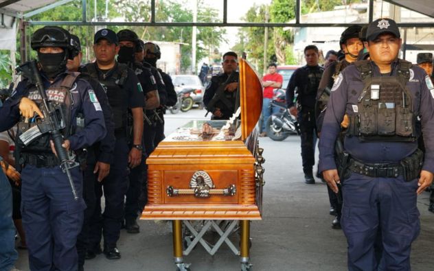 Elementos del Ejército Mexicano y de la policía estatal rinden guardia de honor junto a un féretro en Tlaltizapán, Morelos