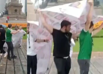 Aficionados aglomerados bajo la lluvia junto a las escalinatas del Ángel de la Independencia en la Ciudad de México