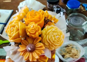 Mujeres elaborando velas aromáticas artesanales con moldes y fragancias en un taller comunitario de Cuernavaca, Morelos